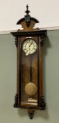 An Edwardian walnut Vienna wall clock, turned finial and carved pediment over enamel dial and