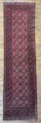 A hand-knotted Afghan Bokhara runner, central panel with rows of guls and stylized motifs enclosed
