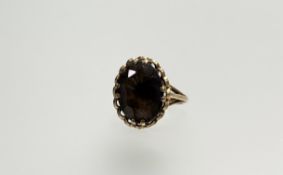 A 9ct gold ring set with an oval facet cut cairngorm stone, approximately 3.5ct chip to side of