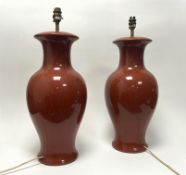 A pair of ceramic table lamps of baluster vase form, finished in a sang-de-boeuf style glaze,