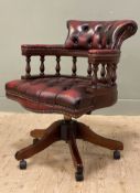 A reproduction captain's style desk chair, button-back with spindles to sides, raised on a revolving