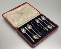 A George V Sheffield silver set of six beaded bordered tea spoons and tongs: l. x 11cm in a fitted