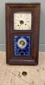 A late 19th century wall clock by Waterbury of Connecticut USA, painted dial to top over painted