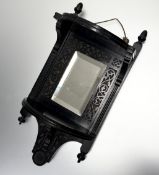 A black painted wooden carved wall bracket, with two shelves, bottom shelf with a mirror panel