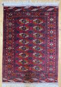 A hand-knotted Turkoman Bokhara rug, central panel with two rows of guls enclosed within a border
