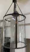 A modern traditional hall lantern, of cylindrical form with bronze finish, opaque glass internal