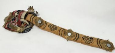 A Balinese mask, hand carved wooden mask decorated in red, gilt, and off-white tones, with yellow