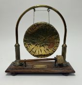 A 20th century brass Burmese table gong, mounted on a wooden base with striker (h. 29cm)