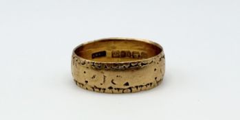 An 18ct gold chased wedding band shows signs of wear, P 4.51g