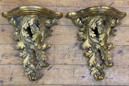 A pair of modern Rococo-style gilt wall brackets, shelf to top over scrolling foliate decoration: H.