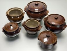 A collection of six treacle glazed lidded cassrole dishes in varying sizes, three marked Pearsons of