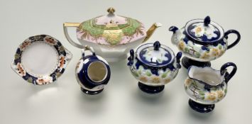A part garden scene with orange flowers pattern teaservice comprising, a teapot, a twin handled