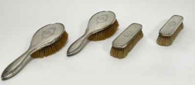 A silver four-piece brush set, comprising two hair brushes and two clothes brushes, each engraved