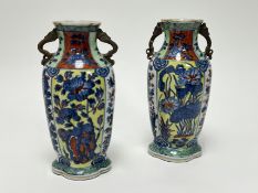 A pair of Chinese porcelain vases of scalloped form with twin serpent handles to sides, decorated in