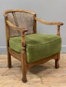 A 1930s French bergere armchair, walnut frame with caned bergere back, green velvet seat raised on