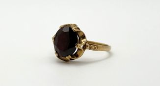 A 9ct gold oval facet cut garnet coloured stone in a six claw setting, approximately 2ct R 2.78g