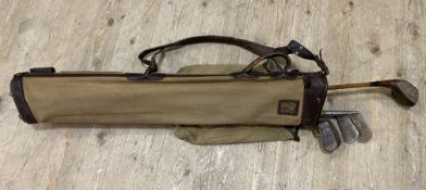 A set of vintage golf clubs, comprising five irons and wood within a canvas and leather bag