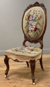 A Victorian walnut nursing chair, carved balloon back with floral needlework back and seat, raised