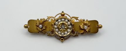 An Edwardian 15ct gold bar brooch, the central star set with a rose cut diamond point within a