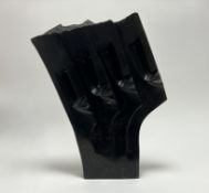 An African abstract hand-carved stone sculpture of four repeated faces, with textured edge,