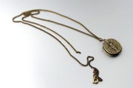 A late 19thc yellow metal engraved fold out oval locket with glazed internal panel a/f and strap