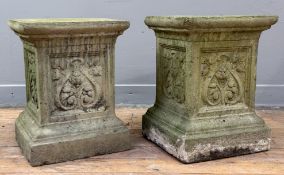 A pair of weathered stone garden pedestals, of square section, decorated to each side with floral