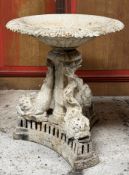 A large painted weathered cast-iron planter, the broad shallow campana bowl on a dolphin-cast tripod