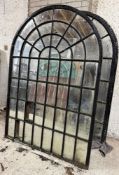 A pair of large cast-iron framed arched garden mirrors of astragalled window form (a/f). Each