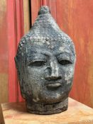 A carved stone head of a Buddha. 36cm.