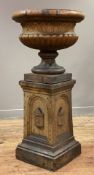 A fireclay urn and pedestal of Classical form, the pedestal with arch and niche, the urn with