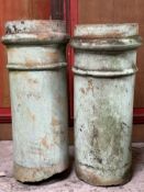 A pair of weathered green-painted stoneware chimney pots (both a/f). Height 77cm.