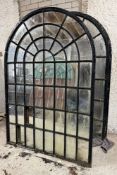 A pair of large cast-iron framed arched garden mirrors of astragalled window form (a/f). Each