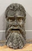 A weathered composition stone wall-mounted mask of 