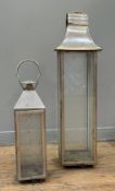 Two glazed white metal garden lanterns, each of square section. Heights including handles 95cm and