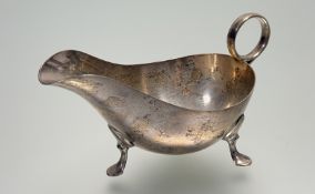 A Sheffield silver sauce boat with ring handle raised on three pad feet: l. x 15cm Sheffield 1945