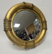 A Regency style wall-hanging mirror, the circular convex plate in a plaster gilt frame, moulded with