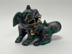 A Chinese porcelain Foo Dog, unusually decorated with gilt scrolls on a blue ground with green and