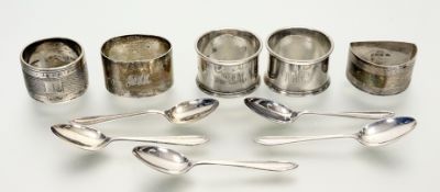 A collection of five various silver napkin rings to include an oval, a crescent and three round with