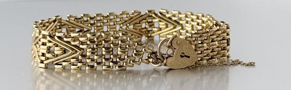 A 9ct gold chevron gate link chain bracelet with heart shaped padlock and safety chain: d. x 8cm 8.