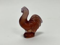 A Lalique crystal figurine in the form of a rooster, finely modelled with detailed feathers in amber
