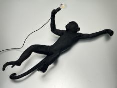 An Italian Seletti resin wall-mounted light fitting, modelled as a climbing monkey, marked to