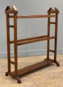 An Edwardian four-bar towel rail, of architectural form with pedimented sides and raised on