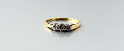 An 18ct gold and platinum set three-stone graduated round cut diamond ring centre stone