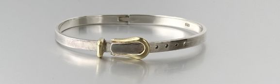 A modern silver cast stiff hinged bangle with yellow metal buckle adjustable fastening: smallest