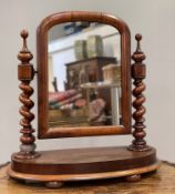 A Victorian mahogany swing mirror, arched plate raised on twin barlet twist supports and finials, on