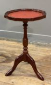 A Georgian-style mahogany wine table, pie-crust edge with red skiver to top, raised on central