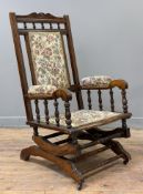 A Victorian mahogany rocking chair, floral upholstered back and seat with spindle sides, raised on