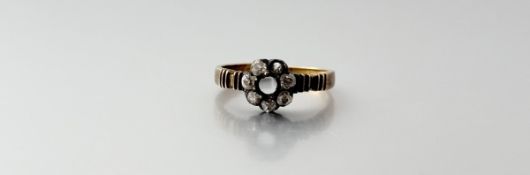 An Edwardian 18ct gold ring set with a surround of eight old mine cut diamonds approximately 0.