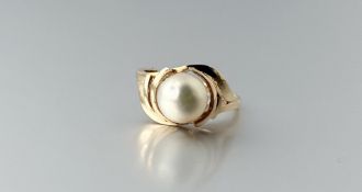 A 14k gold ring set with a freshwater cultured pearl within a scroll setting - cut J/K 3.22g