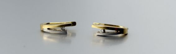 A pair of 18ct yellow and white gold earrings of V form set a brilliant circular diamond
